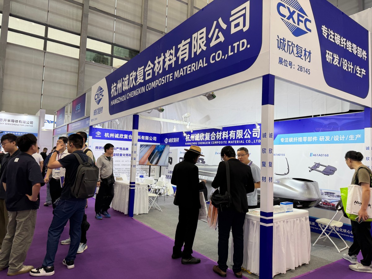 The corporate team of Hangzhou Chengxin Composite Material welcoming clients at the carbon fiber custom manufacturing booth